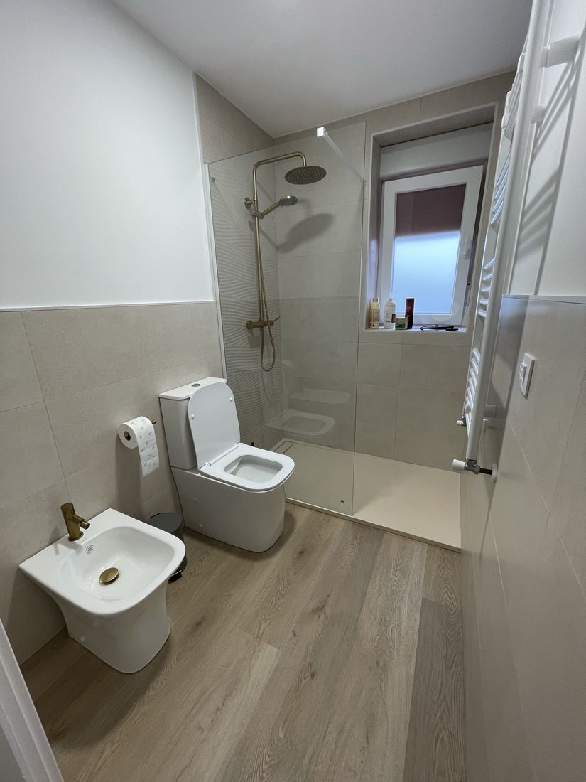 Bathroom with walk-in shower, frameless glass panel and brushed brass fixtures