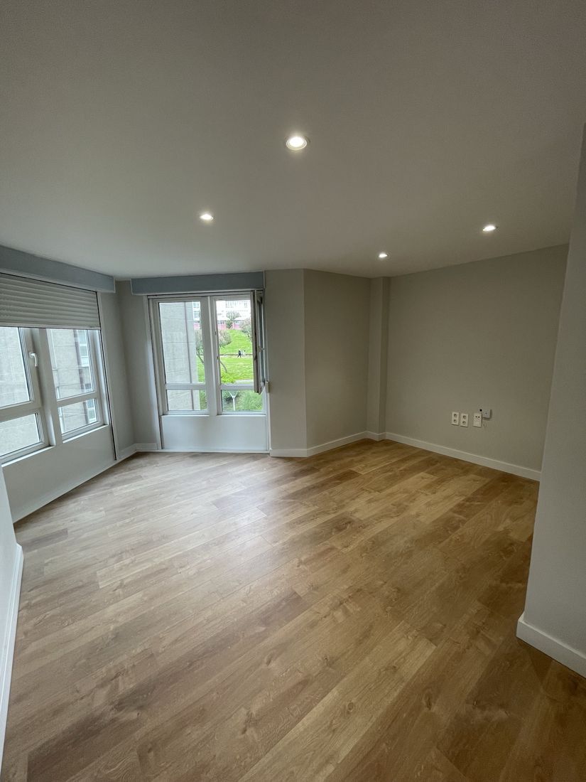 Bright living room with new oak-look flooring, recessed lights and fresh paint