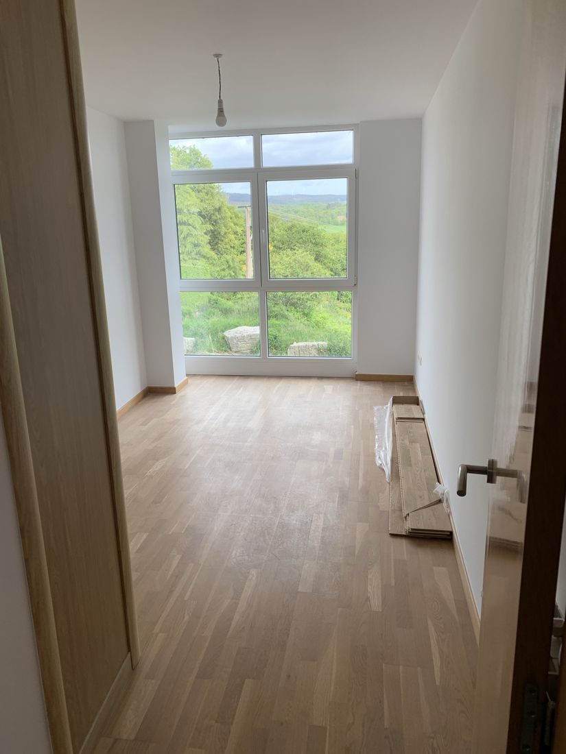 Bright room with new oak flooring and floor-to-ceiling window